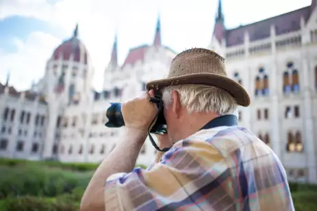 Senior man photographing the Parliament building in Budapest, Hungary.